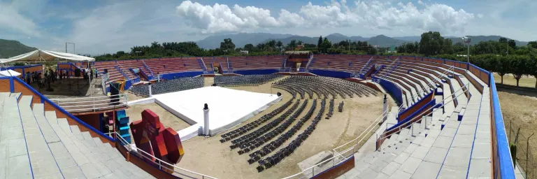 Hero main image of Guelaguetza del Tule festival in Santa María del Tule, Oaxaca, showing a vibrant scene of dancers in traditional costumes performing on stage with a lively audience